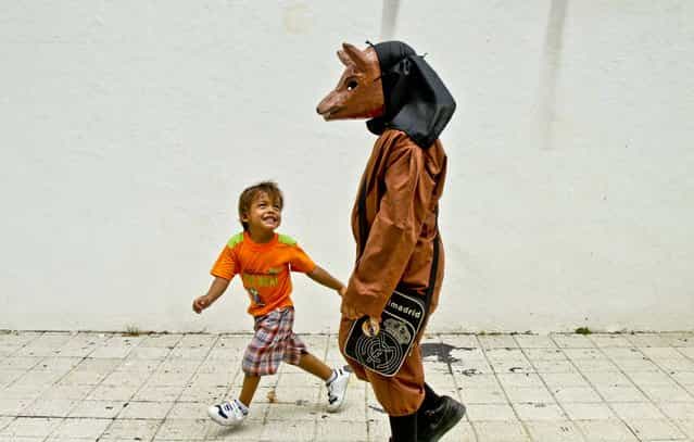 A boy playfully teases another boy dressed in a traditional devil mask and costume during Corpus Christi celebrations in the streets of La Villa, Panama, on May 30, 2013. (Photo by Arnulfo Franco/Associated Press)