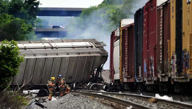 A fire burns at the site of a CSX freight train derailment in Rosedale, Maryland,, on May 28, 2013, where fire officials say the train crashed into a trash truck, causing an explosion that rattled homes at least a half-mile away and collapsed nearby buildings, setting them on fire. (Photo by Kim Hairston/Baltimore Sun/MCT)
