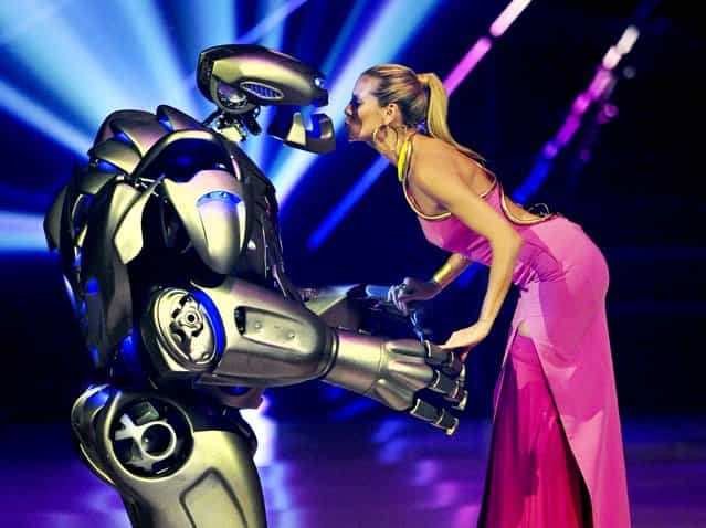 Heidi Klum stands on stage with an actor dressed in a robot costume during the final show of the German television model casting show 'Germany's Next Top model' at the SAP-Arena in Mannheim, Germany, on May 30, 2013. (Photo by Uli Deck/Associated Press)