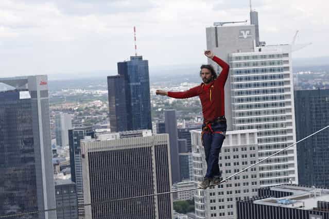 Professional slackliner Reinhard Kleindl walks a high wire in front of the Frankfurt skyline May 25, 2013. Austrian Kleindl set a world record on Saturday by walking the highest urban high line at 607 ft (185 m). (Photo by Ralph Orlowski/Reuters) 