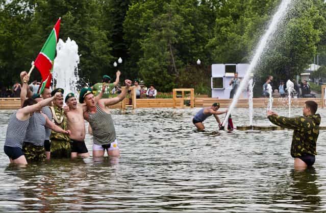 Russian border guards holding pose for a photo while bathing in a fountain in Moscow's Gorky Park as they celebrate the Border Guard's Day in Moscow, on May 28, 2013. (Photo by Misha Japaridze/Associated Press)