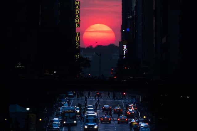 The sun sets along 42nd Street in Manhattan during an annual phenomenon known as [Manhattanhenge], when the sun aligns perfectly with the city's transit grod, Wednesday, May 29, 2013, in New York. (Photo by John Minchillo/AP Photo)