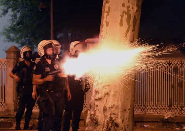 In this photo taken late Saturday, June 1, 2013, riot police fire, as they clash with protestors, near the former Ottoman palace, Dolmabahce, where Turkey's Prime Minister Recep Tayyip Erdogan maintains an office in Istanbul, Turkey. (Photo by AP Photo)
