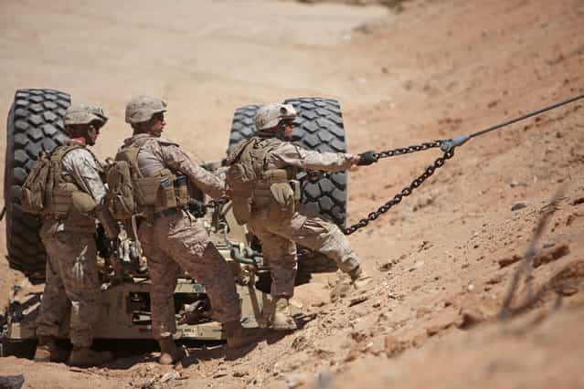 A team of wrecker operators with Combat Logistics Battalion 6, 2nd Marine Logistics Group, hook a seven-ton truck chassis during vehicle recovery training at Twentynine Palms, California, May 25, 2013. The Marines pulled the chassis from a sandy ravine as part of a training exercise meant to prepare them for possible scenarios they may encounter during their upcoming deployment in support of Operation Enduring Freedom. (Photo by Cpl. Paul Peterson/USMC)