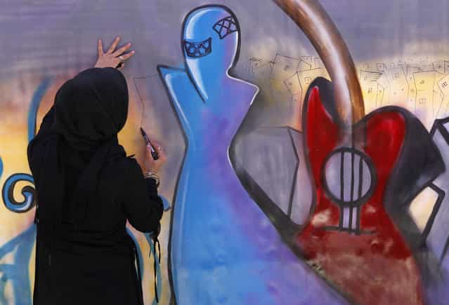 An artist paints graffiti on a wall during the Sound Central music festival in Kabul, on May 1, 2013. (Photo by Omar Sobhani/Reuters)