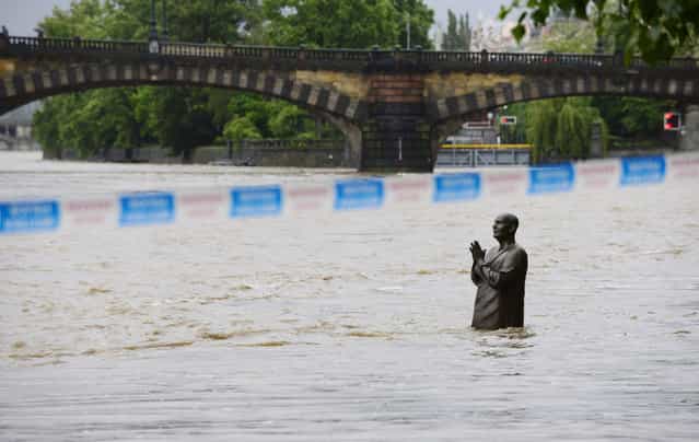 A flooded statue stands in the swollen Vltava river in the center of Prague, Czech Republic, Sunday, June 2, 2013. Heavy rainfalls cause flooding along rivers and lakes in Germany, Austria, Switzerland and the Czech Republic. (Photo by Roman Vondrous/AP Photo/CTK)