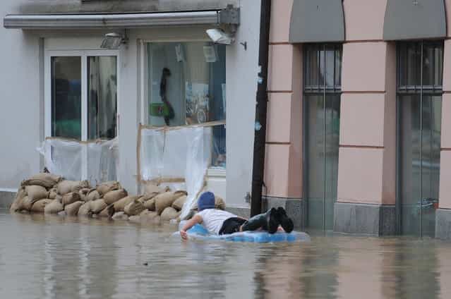A man on a inflatable mattress paddles through a overflooded street in Passau, southern Germany, on June 3, 2013. Parts of the eastern and southern Germany were flooded due to heavy and ongoing rainfalls. (Photo by Andreas Gebert/AFP Photo)