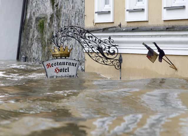 The sign above the door of restaurant and hotel 'Am Paulusbogen' is partially submerged in the flooded centre of the Bavarian town of Passau, about 200 km (124 miles) north-east of Munich June 3, 2013. Torrential rain in the south and south-east of Germany caused heavy flooding over the weekend, forcing people to evacuate their homes. (Photo by Michaela Rehle/Reuters)