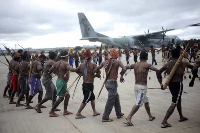 Munduruku Indians do a dance around a Brazilian Air Force plane that transported them to Brasilia for talks with the government, in Brasilia June 4, 2013. Air Force planes flew 144 Munduruku Indians to Brasilia for talks to end a week-long occupation of the controversial Belo Monte dam on the Xingu River, a huge project aimed at feeding Brazil's fast-growing demand for electricity. (Photo by Ueslei Marcelino/Reuters)