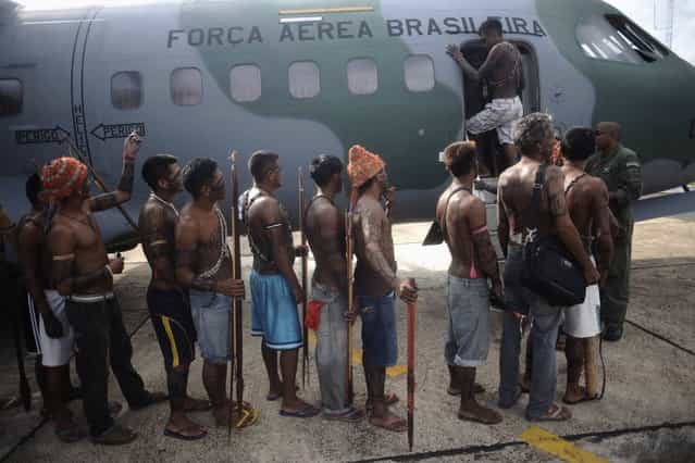 Munduruku Indians, many of who are flying for the first time, board a Brazilian Air Force plane to fly to Brasilia for talks with the government, in Altamira June 4, 2013. Air Force planes flew 144 Munduruku Indians to Brasilia for talks to end a week-long occupation of the controversial Belo Monte dam on the Xingu River, a huge project aimed at feeding Brazil's fast-growing demand for electricity. (Photo by Ueslei Marcelino/Reuters)