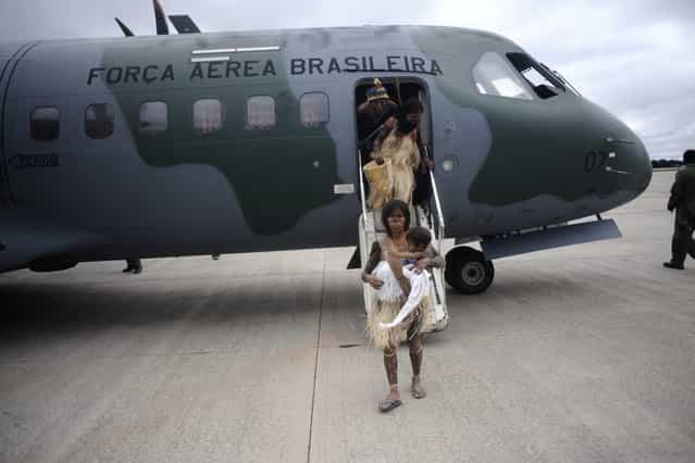 Munduruku Indians, many of who had never been in a plane, disembark from a Brazilian Air Force plane as they arrive for talks with the government, June 4, 2013. Air Force planes flew 144 Munduruku Indians to Brasilia for talks to end a week-long occupation of the controversial Belo Monte dam on the Xingu River, a huge project aimed at feeding Brazil's fast-growing demand for electricity. (Photo by Ueslei Marcelino/Reuters)