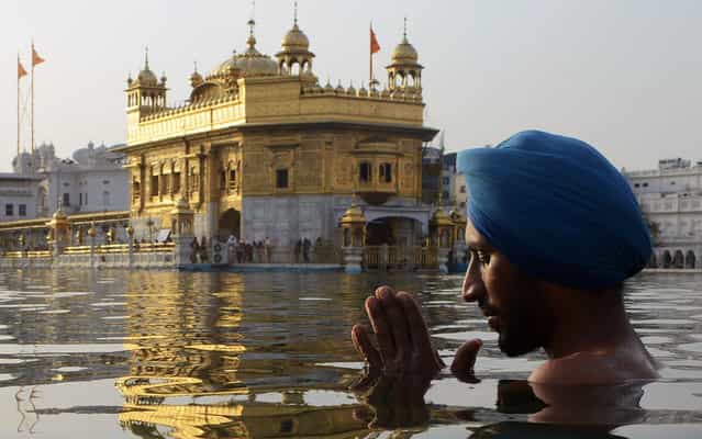 An Indian Sikh devotee takes a dip in the holy sarover (water tank) at the Golden Temple on the eve of [Ghallughara Diwas], the 29th Anniversary of Operation Bluestar, in Amritsar on June 5, 2013. The 1984 assault on the Golden Temple complex by the Indian army was conducted in an attempt to arrest separatists Sikh leader Sant Jarnail Singh Bhindranwale and his militant followers who had initiated a movement for a separate Sikh state. (Photo by Narinder Nanu/AFP Photo)