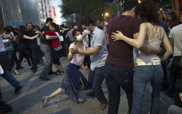 Protestors dance the tango at Gezi Park in Taksim Square on June 6, 2013 in Istanbul, Turkey. The protests began initially over the fate of Taksim Gezi Park, one of the last significant green spaces in the center of the city. The heavy-handed response of the police, Prime Minister Recep Tayyip Erdogan and his government's increasingly authoritarian agenda has broadened the rage of the clashes. (Photo by Uriel Sinai/Getty Images)