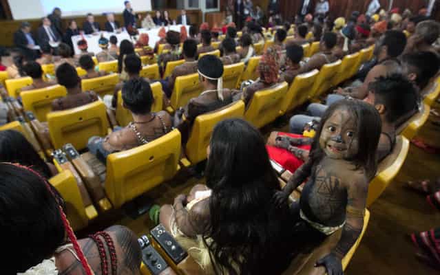 A Munduruku Indian child is pictured at the Planalto Palace, where a meeting with Minister of the General Secretariat of the Presidency of Brazil Gilberto Carvalho was being held with other Munduruku Indians, in Brasilia, June 4, 2013. President Dilma Rousseff's government sought on Tuesday to defuse mounting conflicts with indigenous groups over its decision to stop setting aside farm land for Indians and plans to build more hydroelectric dams in the Amazon. The government flew 144 Munduruku Indians to Brasilia for talks to end a week-long occupation of the controversial Belo Monte dam on the Xingu river, a huge project aimed at feeding Brazil's fast-growing demand for electricity. (Photo by Ed Ferreira/Estadão Conteúdo)