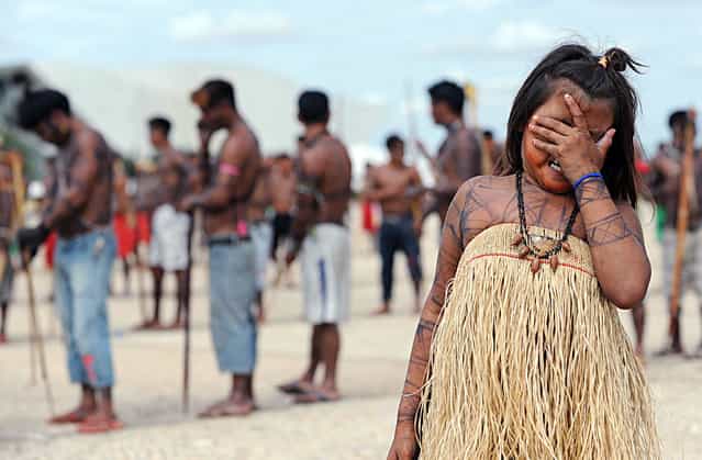 Munduruku natives rally in front of the Planalto Palace in Brasilia, on June 6, 2013. Five indigenous tribes are calling for legislation under which they would have to be consulted prior to any official decision affecting them with respect to the dam's construction. Belo Monte, which is being built at a cost of $13 billion, is expected to flood an area of 500 square km along the Xingu River, displacing 16,000 people, according to the government. Some NGOs have estimated that some 40,000 people would be displaced by the massive project. Indigenous groups say the dam will harm their way of life while environmentalists warn of deforestation, greenhouse gas emissions and irreparable damage to the ecosystem. (Photo by Evaristo Saevaristo/AFP Photo)