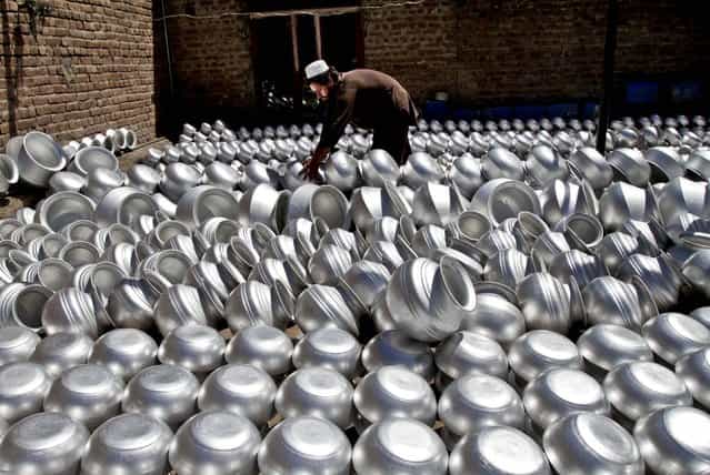 A laborer arranges pots at an aluminum factory in Jalalabad, Afghanistan, on June 5, 2013. Men working at the factory earn an average of $ 7.28 per day. (Photo by Rahmat Gul/Associated Press)