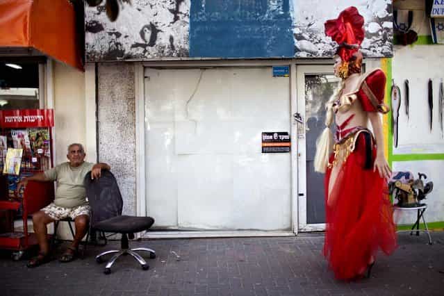 An Israeli drag queen walks along the street during the annual Gay Pride parade in Tel Aviv, on June 7, 2013. Colorful floats with scantily dressed revelers drove through the streets as tens of thousands cheered, waved flags and gyrated to loud music. (Photo by Oded Balilty/Associated Press)
