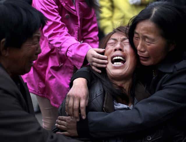 A family member of a worker cries near the accident site of Monday's fire at a poultry processing workshop in Dehui City, China, on June 4, 2013. The swift-moving fire trapped panicked workers inside the poultry slaughterhouse that had only a single open exit, killing at least 119 people in one of the country's worst industrial disasters in years. (Photo by Jin Liwang/Xinhua)