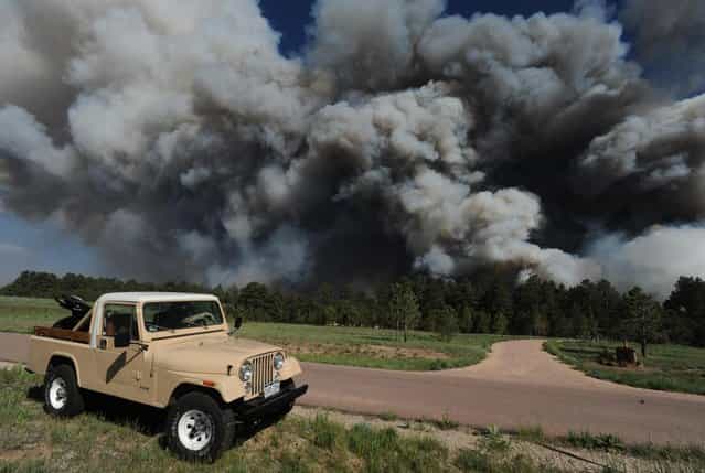 Bill Moreau watches as the Black Forest fire burns near his house near Black Forest Road Tuesday afternoon, June 11, 2013, near Colorado Springs, Colo. The Black Forest Fire was one of at least three significant wildfires burning in Colorado amid gusty winds and record-breaking hot, dry weather. (Photo by Christian Murdock/AP Photo/The Colorado Springs Gazette)