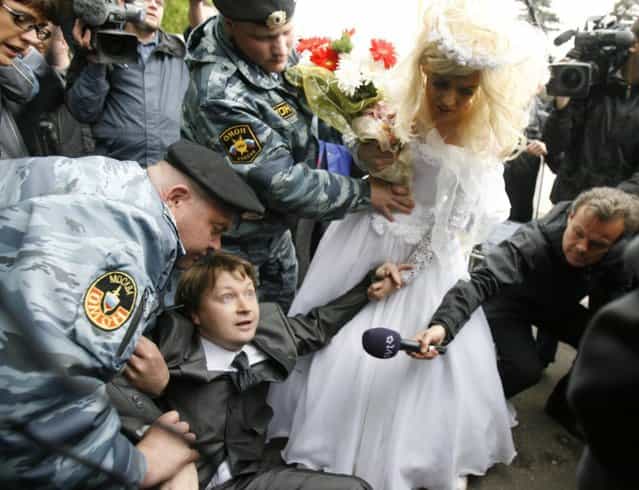 Police detain Russian gay rights leader Nikolai Alexeyev after he arrived with a man dressed in a bridal gown at an unsanctioned gay rights protest in Moscow May 16, 2009. Dozens of riot police broke up a gay rights demonstration on Saturday ahead of the Eurovision Song Contest final, grabbing protesters and throwing them into police cars and a waiting bus. (Photo by Thomas Peter/Reuters)