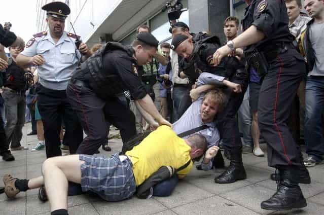 Policemen break up a fight between a gay rights activist and an anti-gay rights activist (in yellow) during a protest against a proposed new law termed by the State Duma, the lower house of Parliament, as [against advocating the rejection of traditional family values] in central Moscow June 11, 2013. (Photo by Maxim Shemetov/Reuters)