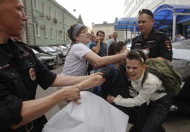 A radical Orthodox believer (C) crushes an egg on a gay rights activist during a protest against a proposed new law termed by the State Duma as [against advocating the rejection of traditional family values] in central Moscow June 11, 2013. Russian police detained more than 20 gay rights activists involved in a [kissing protest] on Tuesday outside parliament where lawmakers were preparing to pass a bill banning homosexual [propaganda]. (Photo by Maxim Shemetov/Reuters)