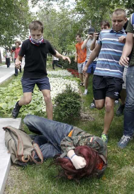 Youths kick a gay rights activist during a protest against a proposed new law termed by the State Duma, the lower house of Parliament, as [against advocating the rejection of traditional family values] in central Moscow June 11, 2013. (Photo by Maxim Shemetov/Reuters)