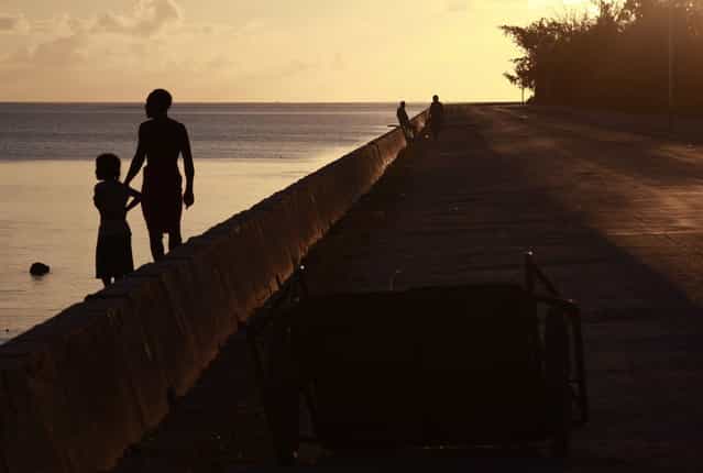 Locals stand on a causeway, which allows travel between the atolls of South Tarawa, near the town of Bairiki in the central Pacific island nation of Kiribati May 25, 2013. (Photo by David Gray/Reuters)