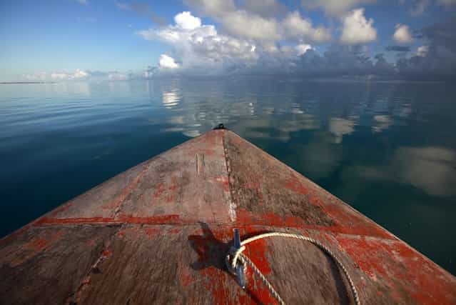A boat floats in the lagoon near Bikeman islet, located off South Tarawa in the central Pacific island nation of Kiribati May 25, 2013. (Photo by David Gray/Reuters)