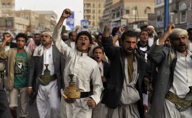 Yemeni Shiite Hawthis chant slogans as they march during a demonstration demanding the release of political detainees near intelligence headquarters in Sanaa, Yemen, Monday, June 10, 2013. Clashes between Shiite protesters and security forces in Yemen's capital Sunday killed many people and wounded more than 80, a Yemeni security official said. (Photo by Hani Mohammed/AP Photo)