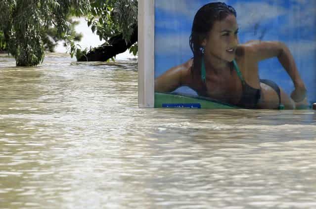 A partially submerged billboard on a tramstop is seen on the flooded embankments of the Danube River in Budapest June 10, 2013. The Hungarian capital escaped damage from the swollen river Danube, which peaked at record high levels in Budapest overnight and started receding slowly on Monday morning. (Photo by Laszlo Balogh/Reuters)