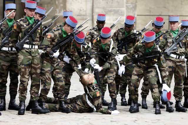 French Army soldiers of the 2nd Regiment of dragons help a fellow soldier who fainted during a ceremony to pay tribute to late former French Prime Minister Pierre Mauroy in the courtyard of the Invalides in Paris June 11, 2013. Mauroy, who pushed through a string of worker benefits as the head of modern France's first Socialist government, has died aged 84, on June 7, 2013. (Photo by Charles Platiau/Reuters)