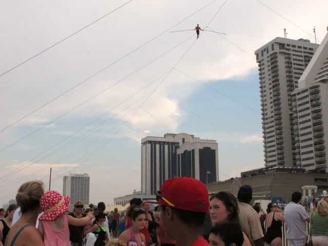 A crowd watches as daredevil Nik Wallenda walks a tightrope above the beach at Atlantic City on Thursday, Aug. 9, 2012. Officials say some 150,000 people witnessed the walk. (Photo by Geoff Mulvihill/AP Photo)