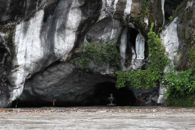 View of the Grotto of Lourdes flooded, in Lourdes, southwestern France, Tuesday, June 18, 2013. French rescue services and police are evacuating hundreds of pilgrims from hotels threatened by floodwaters from a rain-swollen river in the Roman Catholic shrine town of Lourdes. (Photo by Bob Edme/AP Photo)