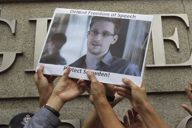 Protesters supporting Edward Snowden, a contractor at the National Security Agency (NSA), hold a photo of Snowden during a demonstration outside the U.S. Consulate in Hong Kong June 13, 2013. China's Foreign Ministry offered no details on Thursday on Snowden, the National Security Agency contractor who revealed the U.S. government's top-secret monitoring of phone and Internet data and who is in hiding in Hong Kong. (Photo by Bobby Yip/Reuters)