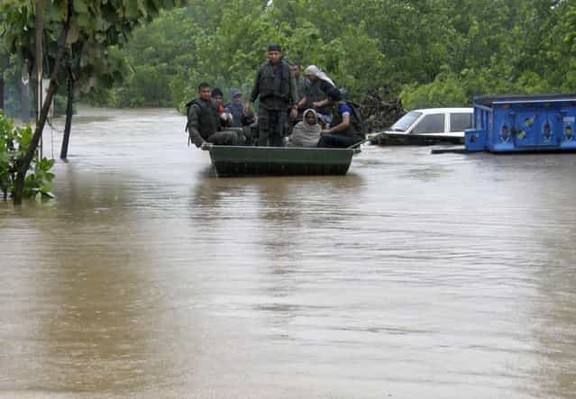 Indian army soldiers rescue stranded villagers in a boat after floods triggered by heavy rains at Odhri village in Yamunanagar district of the northern Indian state of Haryana June 17, 2013. The rains usually cover all of India by mid-July, but this year it happened on June 16, the earliest such occurrence on record, a senior official at the India Meteorological Department said. (Photo by Reuters/Stringer)