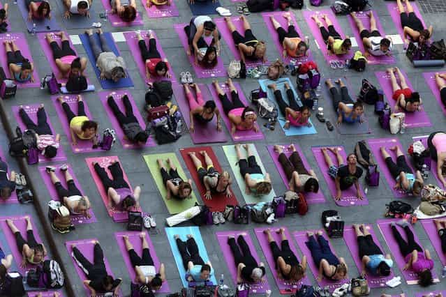Yoga enthusiast mark the longest day of the year with five free [Mind Over Madness] yoga classes in New York's Times Square, on June 21, 2013. (Photo by Mary Altaffer/Associated Press)