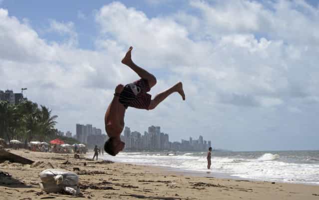 A man does a somersault at Boa Viagem Beach in Recife June 19, 2013. (Photo by Marcos Brindicci/Reuters)