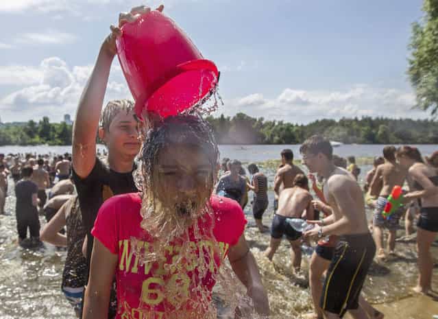 Youth spray water on each other on the banks of the Dnipro River in Kiev June 16, 2013. Some 250 people participated in a social media flash mob called [Water Battle]. (Photo by Valentyn Ogirenko/Reuters)