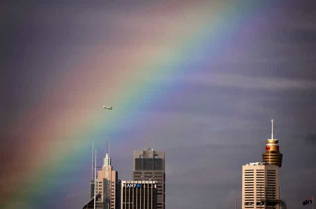 A Qantas Boeing 737 airplane flies through a rainbow above the central business district of Sydney June 17, 2013. (Photo by David Gray/Reuters)