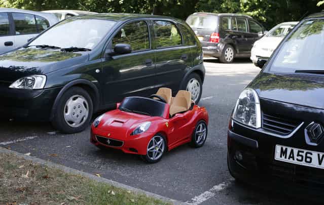 A child's toy Ferrari is parked between two hatchbacks at the Hale Barns Cricket Club in Altrincham, Cheshire, northern England June 19, 2013. (Photo by Phil Noble/Reuters)