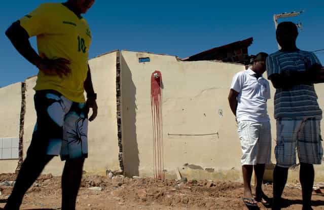A miniature football pinned to a wall with red paint symbolizing blood is seen in Fortaleza, Northeastern Brazil, on June 19, 2013 during a protest of what is now called the [Tropical Spring] against corruption and price hikes. In a country with one of the widest income disparities in the world – billions of dollars were being spent on stadiums and little on social programs – and the Confederations Cup football tournament going on, Brazil has two weeks to convince sceptics that it can honour its pledge to stage a successful World Cup in 2014. (Photo by Yuri Cortez/AFP Photo)