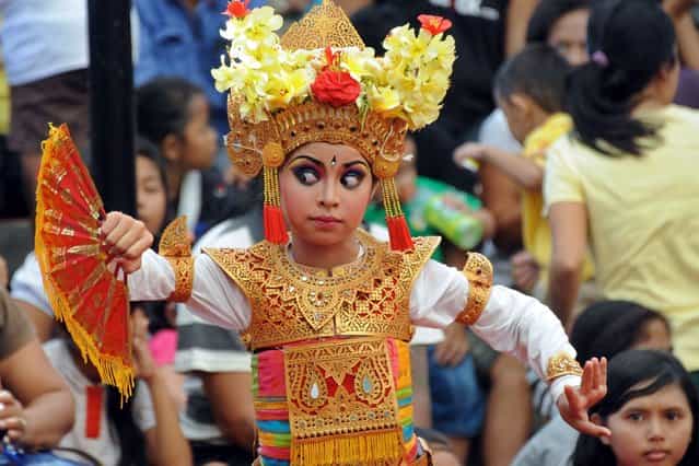 A Balinese girl performs a traditional dance during the 35th Bali Art Festival in Denpasar on Indonesia's resort island of Bali on June 21, 2013. The Bali Arts Festival is a full month of daily performances, handicraft exhibitions and other related cultural and commercial activities during offerings of dance, music and beauty. The festival is designed to promote tourism on the resort island. (Photo by AFP Photo)