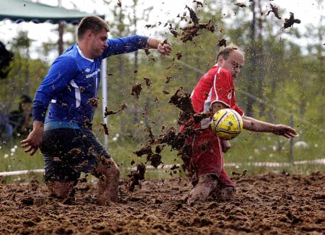 Athletes fight for a ball during a Swamp Soc Cup of Russia soccer match, outside St. Petersburg, on June 15, 2013. (Photo by Dmitry Lovetsky/Associated Press)