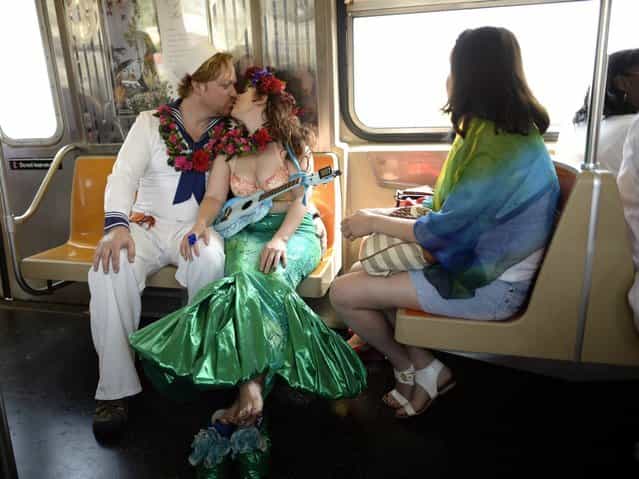 parade participants ride the subway in costume for the 31st Annual Mermaid Parade at New York's Coney Island on June 22, 2103. Over 700,00 people are exptected to turn out for the scantily clad parade. AFP PHOTO / TIMOTHY CLARY (Photo credit should read TIMOTHY CLARY/AFP/Getty Images)