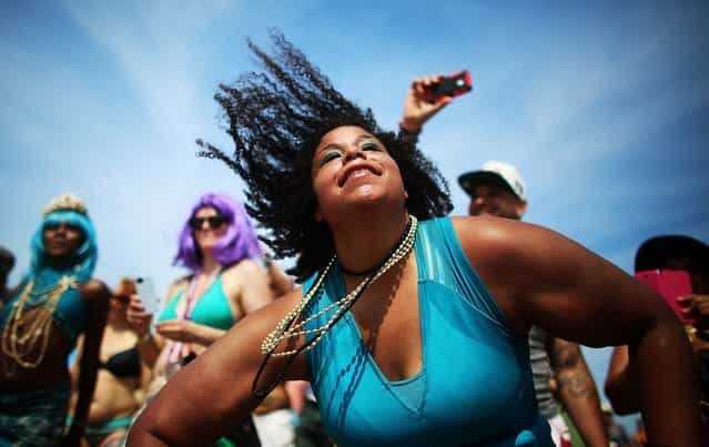 NEW YORK, NY - JUNE 22: Revelers dance on the beach at the 2013 Mermaid Parade at Coney Island on June 22, 2013 in the Brooklyn borough of New York City. Coney Island was hard hit by Superstorm Sandy but parade organizers, whose offices were flooded, were able to raise $100,000 on Kickstarter to fund the parade. The Mermaid Parade began in 1983 and features participants dressed as mermaids and other sea creatures while paying homage to the former tradition of the Coney Island Mardi Gras, which ran annually in the early fall from 1903-1954. (Photo by Mario Tama/Getty Images)