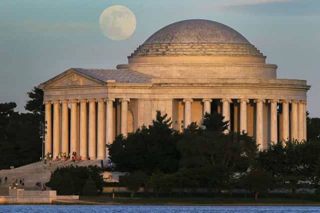 A full moon rises behind the Jefferson Memorial in Washington Saturday, June 22, 2013. The larger than normal moon called the [Supermoon] happens only once this year as the moon on its elliptical orbit is at its closest point to earth. (Photo by J. David Ake/AP Photo)