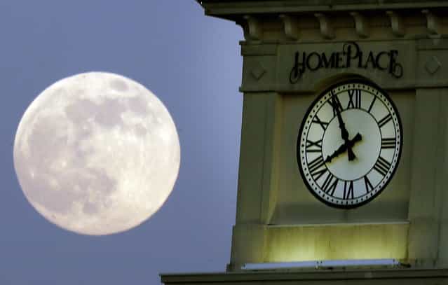 A [supermoon] rises behind the Home Place clock tower in Prattville, Ala., Saturday, June 22, 2013. (Photo by Dave Martin/AP Photo)