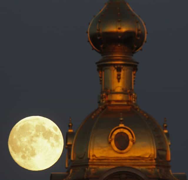 The moon rises behind the Peter and Pawel Fortress in St. Petersburg June 22, 2013. (Photo by Alexander Demianchuk/Reuters)
