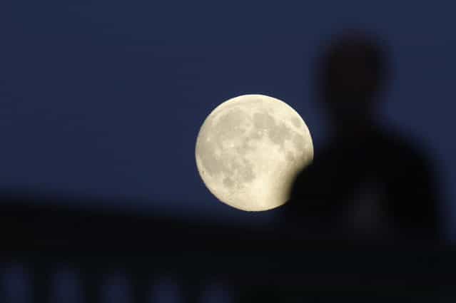 The moon rises over the Ioannovsky Bridge as a pedestrian walks across in St. Petersburg June 22, 2013. The largest full moon of the year, called the [supermoon], will light up the night sky this weekend. (Photo by Alexander Demianchuk/Reuters)